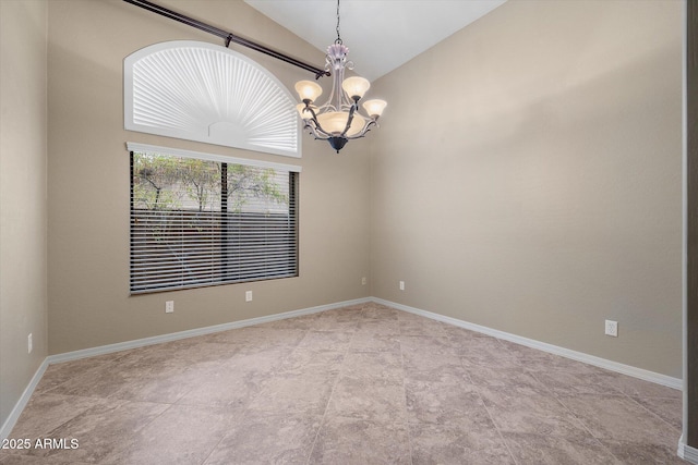 spare room featuring a chandelier and vaulted ceiling