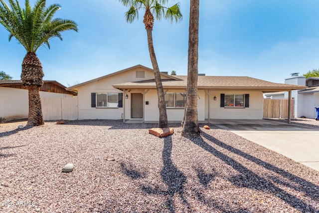 ranch-style home with brick siding, a carport, and fence