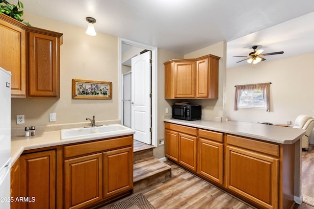 11180 E Navajo Dr, Dewey, AZ 86327 - kitchen with brown cabinets, a ceiling fan, black microwave, and a sink