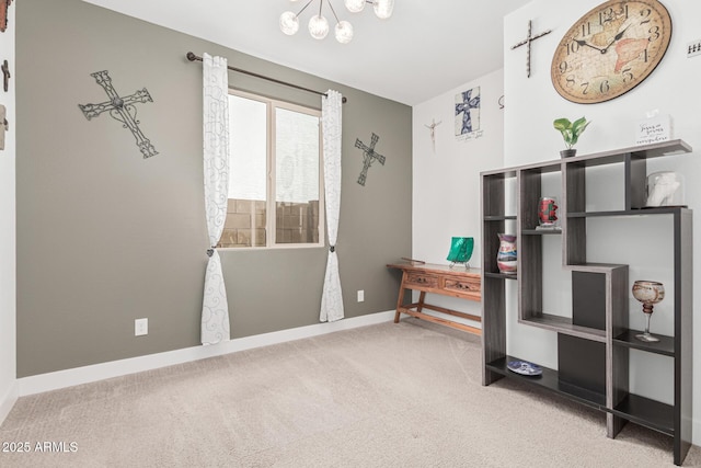 interior space with baseboards, carpet floors, and a chandelier