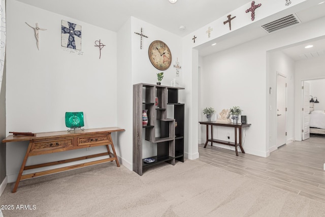 hallway featuring recessed lighting, visible vents, baseboards, and wood finished floors