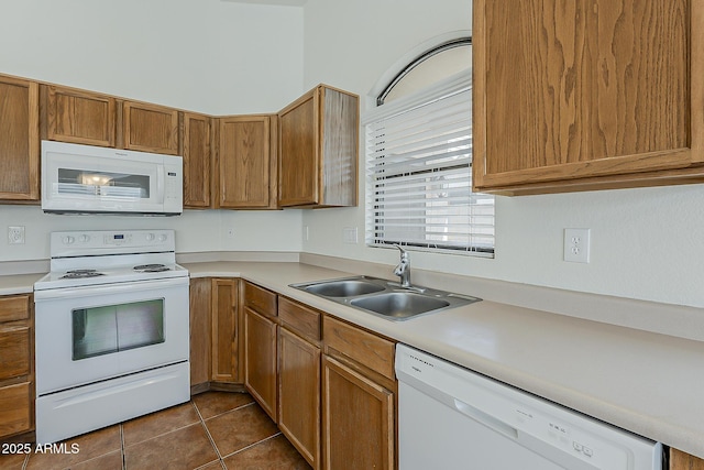 kitchen with light countertops, a sink, and white appliances
