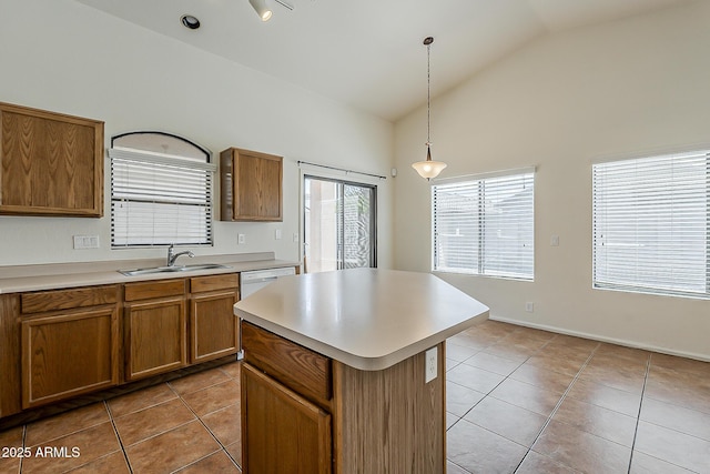 kitchen with a sink, brown cabinets, pendant lighting, light countertops, and light tile patterned floors