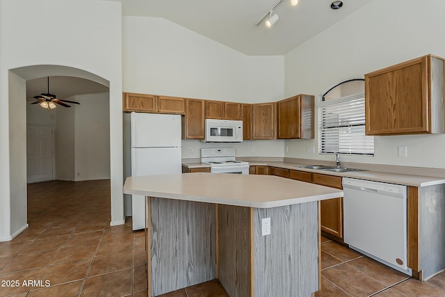 kitchen with ceiling fan, white appliances, high vaulted ceiling, and a sink