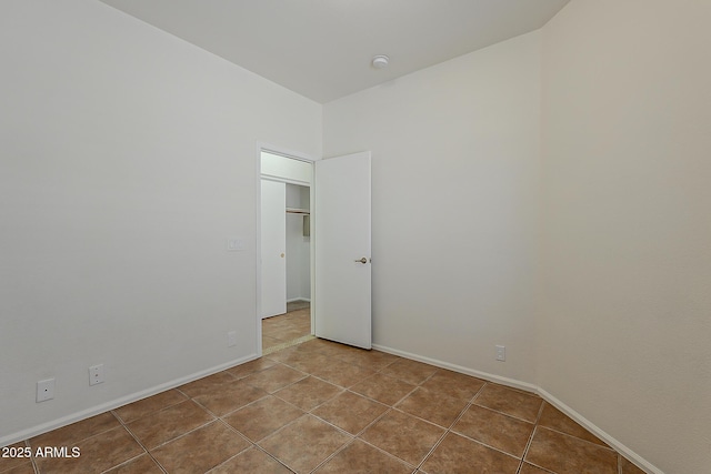 unfurnished bedroom with baseboards and tile patterned floors
