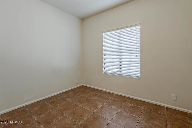 spare room featuring baseboards and tile patterned floors