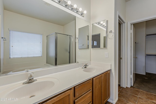 full bathroom featuring a sink, tile patterned flooring, double vanity, and a shower stall