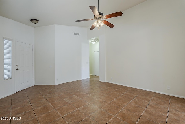 empty room with tile patterned floors, visible vents, and a ceiling fan