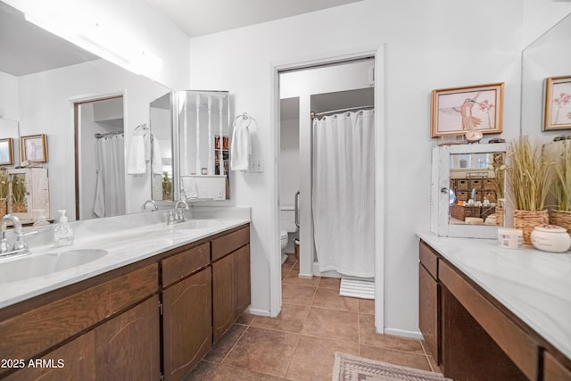 bathroom with double vanity, toilet, tile patterned flooring, and a sink