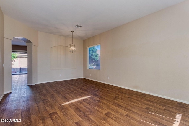 6970 W Paso Trl, Peoria, AZ 85383 - spare room featuring a chandelier, visible vents, arched walkways, and dark wood-style flooring