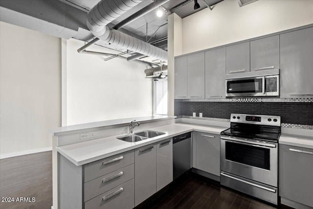 kitchen featuring appliances with stainless steel finishes, dark hardwood / wood-style flooring, gray cabinetry, and sink