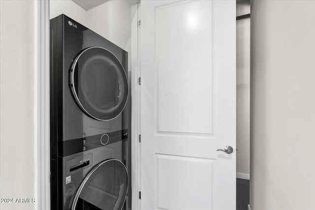 clothes washing area featuring stacked washer and clothes dryer