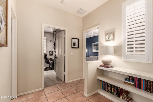 7617 E Desert Honeysuckle Dr, Gold Canyon, AZ 85118 - hallway featuring a desk, light tile patterned flooring, and baseboards