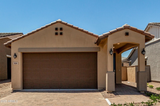 5656 N 205th Ln, Buckeye, AZ 85396 - view of front of home featuring an attached garage, stucco siding, a tile roof, and driveway
