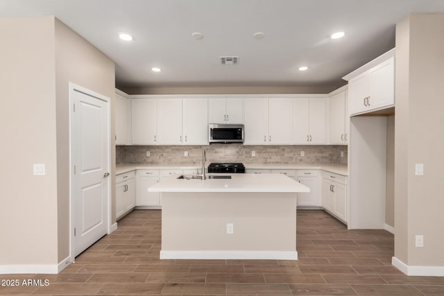 5656 N 205th Ln, Buckeye, AZ 85396 - kitchen with stainless steel microwave, a sink, wood tiled floors, decorative backsplash, and recessed lighting