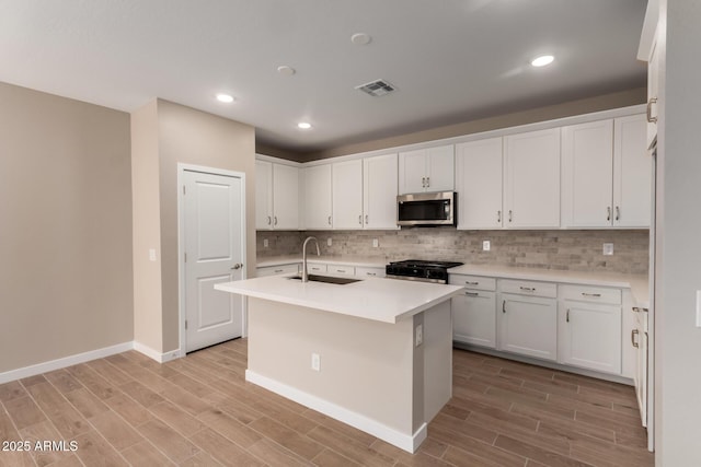 5656 N 205th Ln, Buckeye, AZ 85396 - kitchen with a sink, stainless steel microwave, light wood-style flooring, white cabinets, and recessed lighting