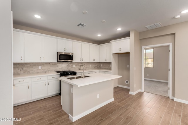 5656 N 205th Ln, Buckeye, AZ 85396 - kitchen with stainless steel microwave, light wood-type flooring, backsplash, gas range, and light countertops