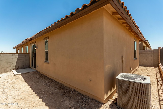 5656 N 205th Ln, Buckeye, AZ 85396 - view of property exterior with central AC unit, a fenced backyard, stucco siding, and a tile roof
