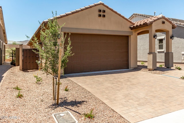 5656 N 205th Ln, Buckeye, AZ 85396 - view of front facade featuring a tile roof, an attached garage, stucco siding, driveway, and a gate