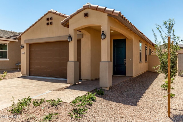 5656 N 205th Ln, Buckeye, AZ 85396 - mediterranean / spanish house featuring a tiled roof, an attached garage, stucco siding, and decorative driveway