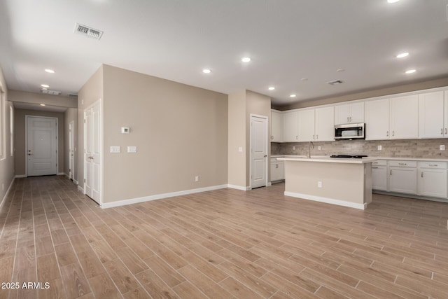 5656 N 205th Ln, Buckeye, AZ 85396 - kitchen with stainless steel microwave, light countertops, backsplash, baseboards, and recessed lighting