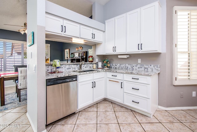 kitchen with stainless steel dishwasher, light tile patterned flooring, and a sink