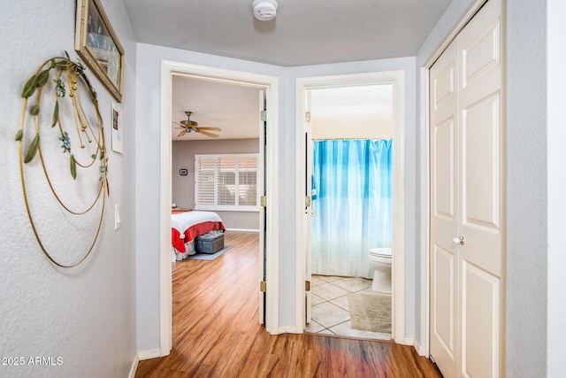 hall featuring baseboards and wood finished floors