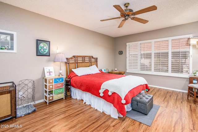 bedroom with baseboards, a textured ceiling, wood finished floors, and a ceiling fan