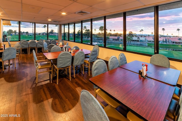 dining space with visible vents, a paneled ceiling, and wood finished floors