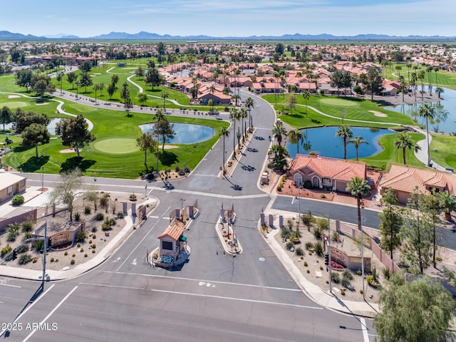 drone / aerial view with golf course view, a residential view, and a water and mountain view