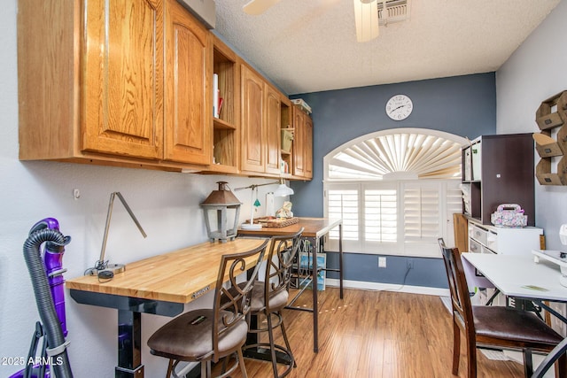 kitchen with visible vents, open shelves, a textured ceiling, light wood finished floors, and ceiling fan