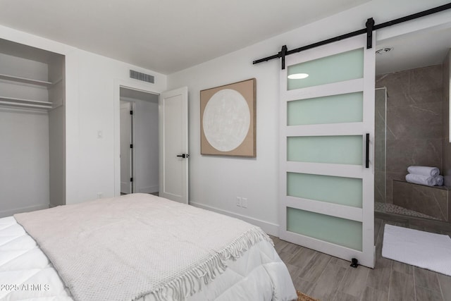 1909 N 74th St, Scottsdale, AZ 85257 - bedroom with a barn door, wood finished floors, and a closet
