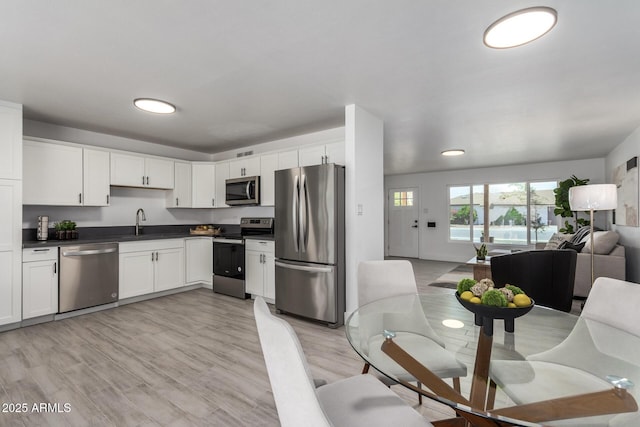 1909 N 74th St, Scottsdale, AZ 85257 - kitchen with stainless steel appliances, open floor plan, dark countertops, and white cabinetry