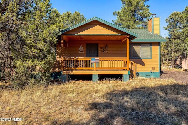 2086 Pinewood Dr, Overgaard, AZ 85933 - chalet / cabin featuring a chimney, a porch, roof with shingles, and crawl space