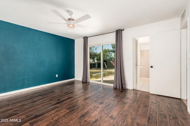 spare room with baseboards, visible vents, a ceiling fan, and wood finished floors