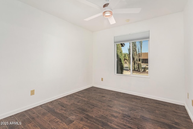 empty room with dark wood finished floors, a ceiling fan, and baseboards