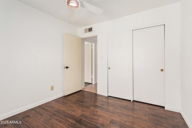 unfurnished bedroom featuring a closet, visible vents, ceiling fan, wood finished floors, and baseboards