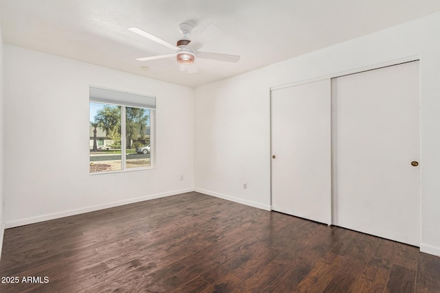 unfurnished bedroom featuring ceiling fan, a closet, wood finished floors, and baseboards