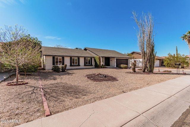 single story home with concrete driveway and an attached garage