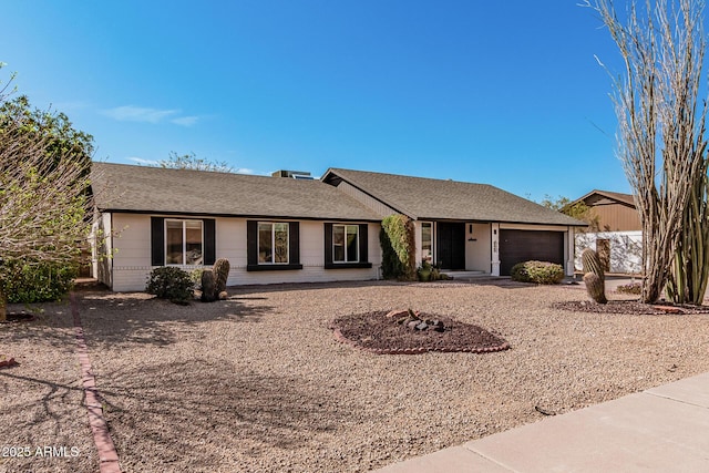 single story home featuring a garage, brick siding, and a shingled roof