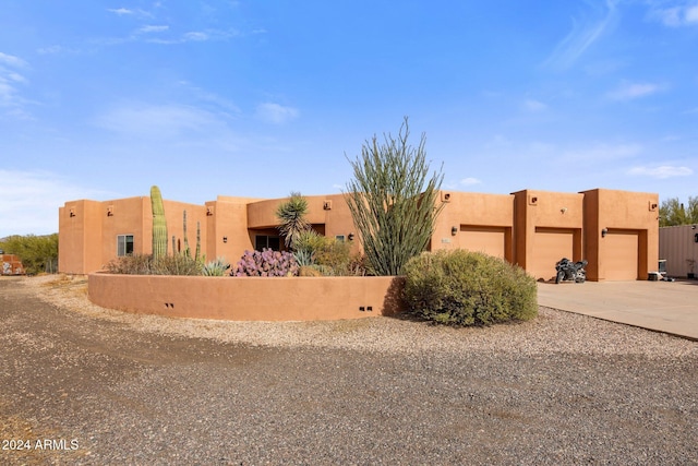 pueblo revival-style home with a garage