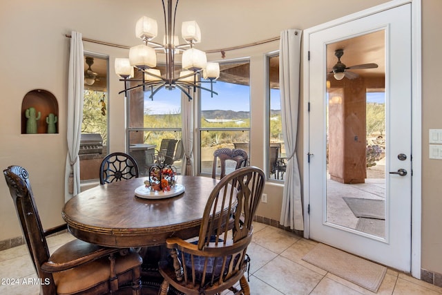 dining room featuring ceiling fan with notable chandelier, a healthy amount of sunlight, and light tile patterned floors