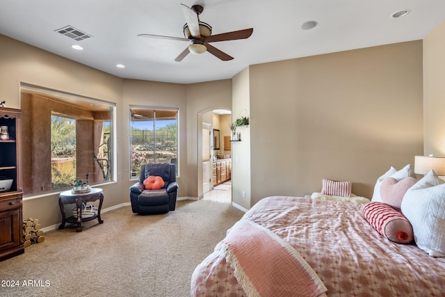 bedroom featuring connected bathroom, ceiling fan, and light carpet