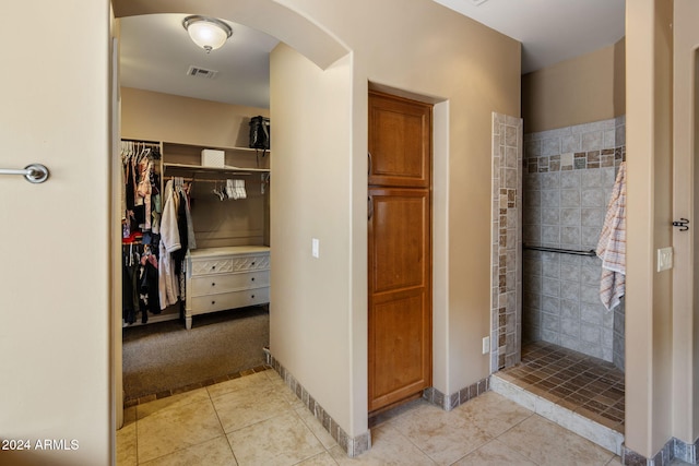 bathroom featuring tile patterned floors and tiled shower