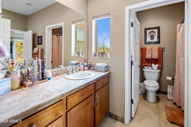 bathroom featuring a wealth of natural light, tile patterned flooring, vanity, and toilet