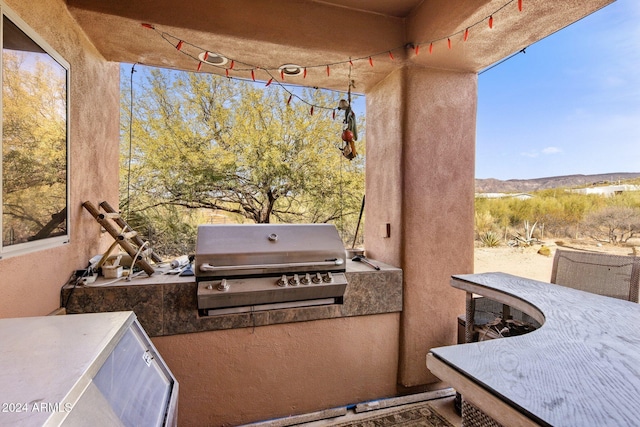 view of patio / terrace with a grill, a mountain view, and exterior kitchen