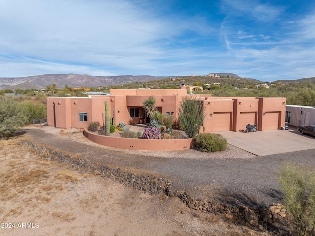 pueblo-style home with a mountain view and a garage