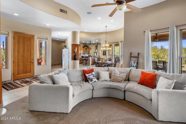 living room with ceiling fan with notable chandelier and light tile patterned floors