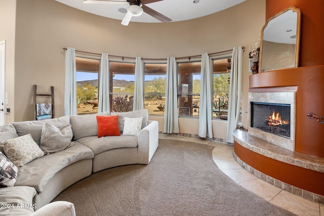 tiled living room with ceiling fan, a mountain view, and a wealth of natural light