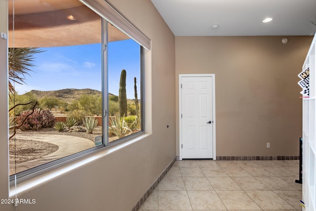 corridor featuring a mountain view and light tile patterned floors